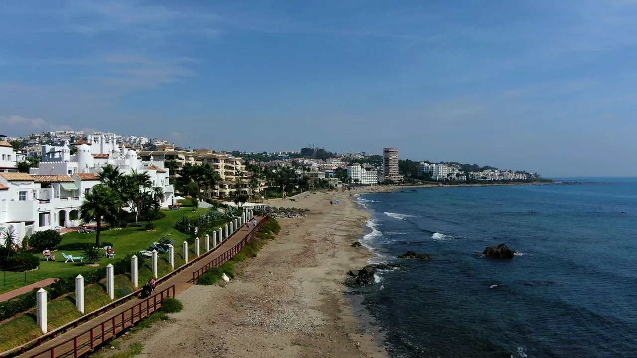 A wooden boardwalk along the beach, the sea on the right