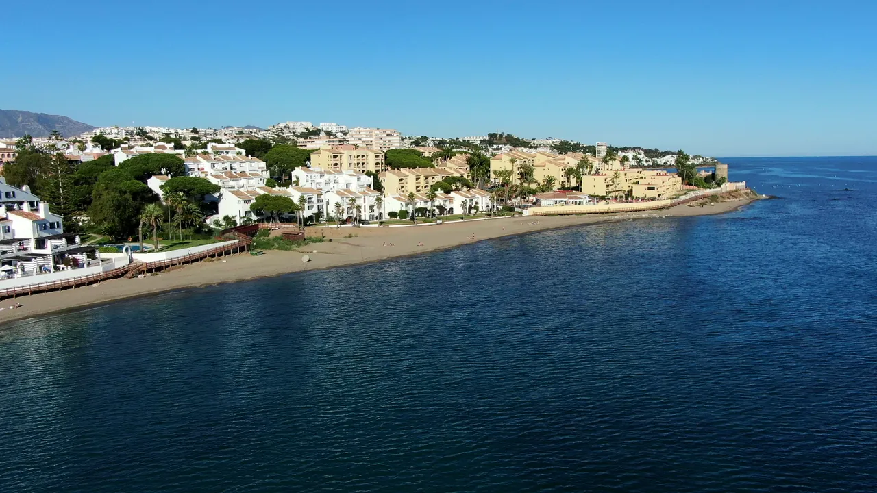 The beach and the coast of Calahonda from the air, the sea in the foreground