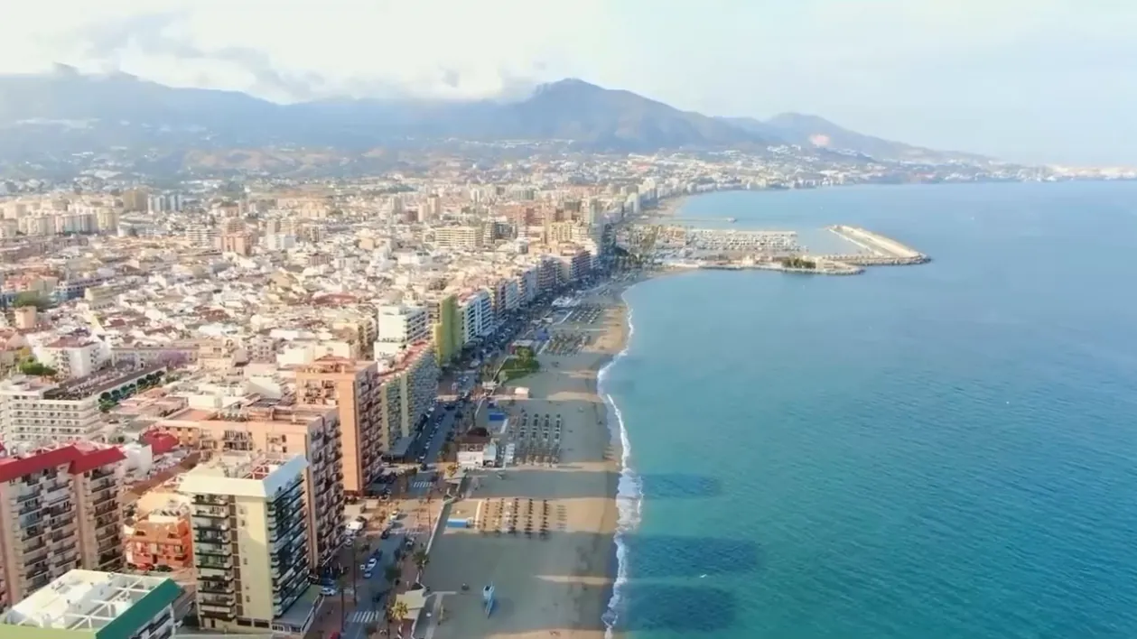 Fuengirola from the air: the town, the beach and the marina, the mountains behind